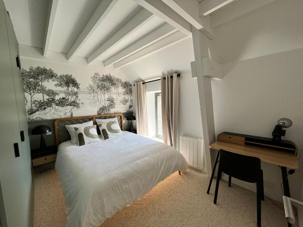 une chambre avec un lit, un bureau et une fenêtre dans l'établissement Délicieuse escapade, à Saint-Coulomb