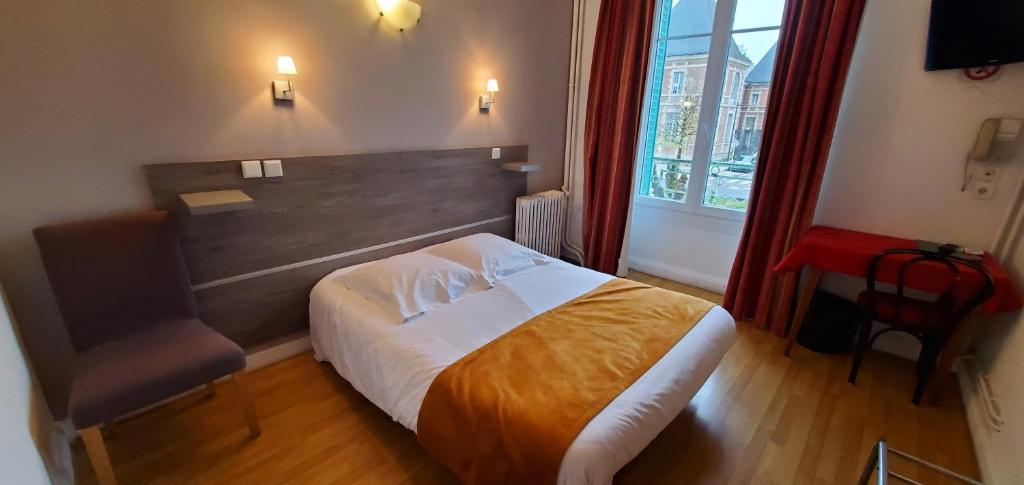 een slaapkamer met een bed, een stoel en een raam bij Hotel Bar Restaurant Saint Paul in Verdun-sur-Meuse