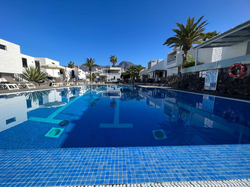 a blue swimming pool with a cross in the middle at Apartamento Bungamerica 2 bedrooms Costa Adeje in Playa de las Americas