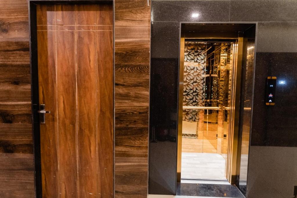 a wooden door and a mirror in a building at HOTEL AYODHYA in Virpur