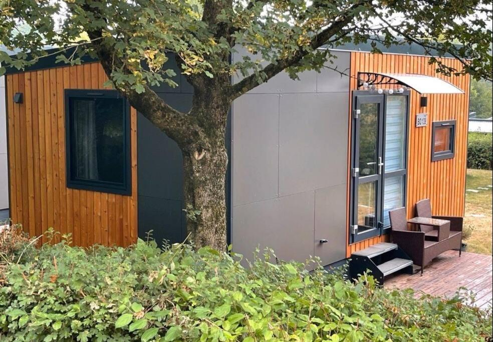ein winziges Haus neben einem Baum in der Unterkunft Tinyhouse am See im Donau-Ries in Wemding