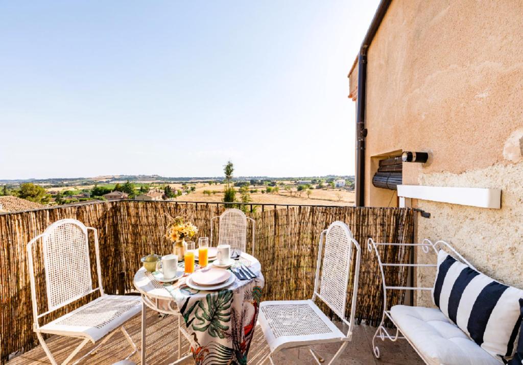 uma mesa e cadeiras numa varanda com vista em Apartamentos Vino Tinto em Adahuesca