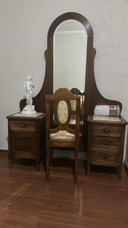 a chair and a dresser with a mirror on it at Casa Grande Hospedagem in Brumadinho