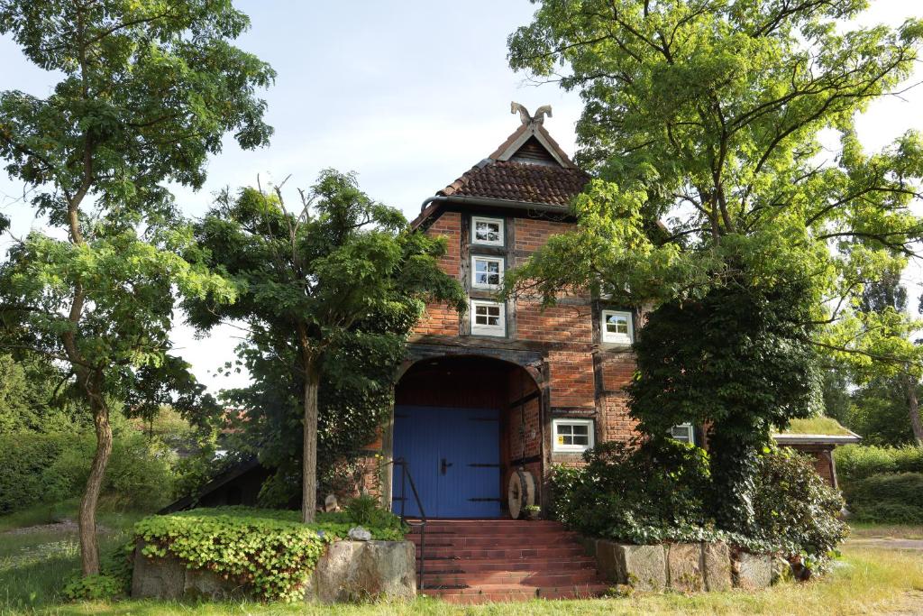 an old brick house with a blue door at Ferienwohnung im Heidjerhaus in Suderburg