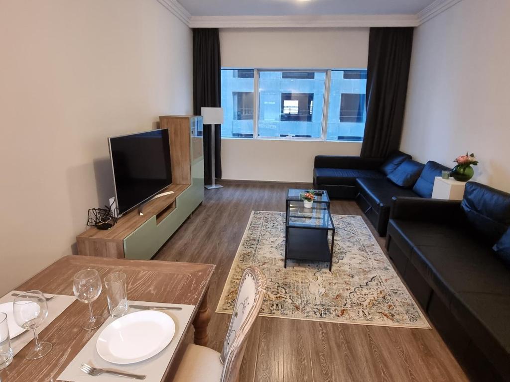 - un salon avec un canapé et une table dans l'établissement Granada Apartments MAG 218, à Dubaï