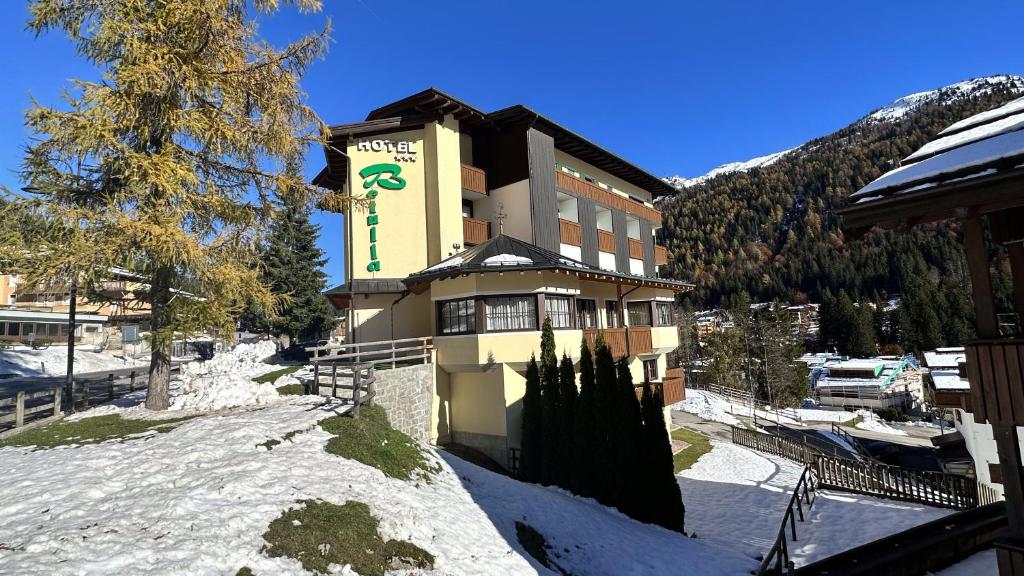 Un bâtiment avec un panneau dans la neige dans l'établissement Hotel Betulla, à Madonna di Campiglio