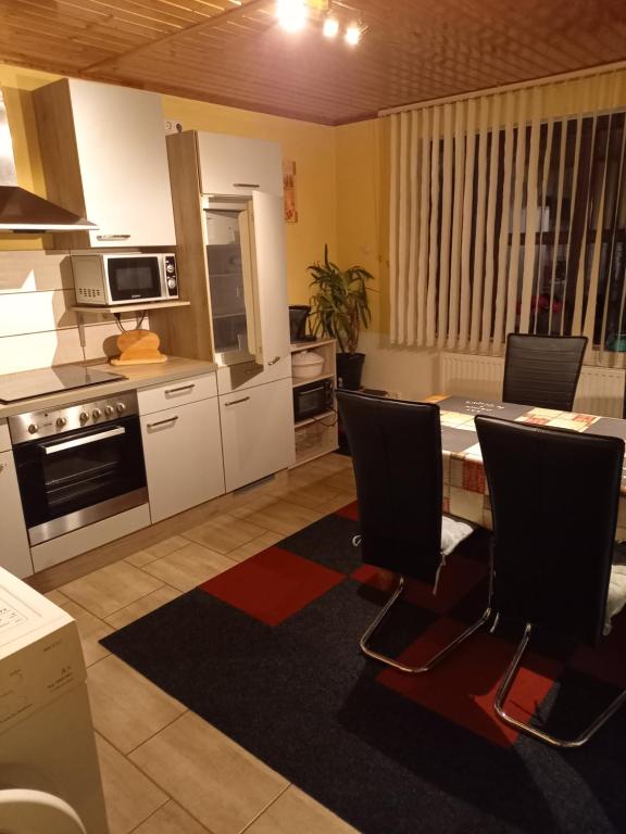 a kitchen with a table and chairs in a room at Monteur- und Ferienwohnung Waldrauschen in Fehrenbach