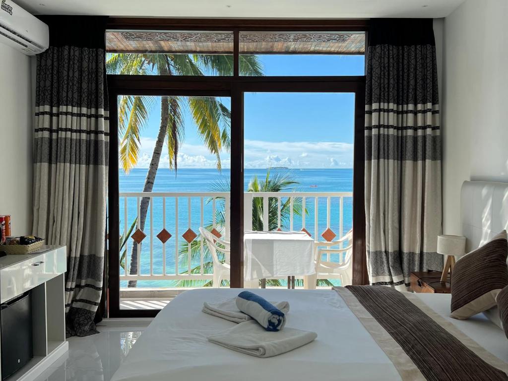 a bedroom with a bed and a view of the ocean at Heron Beach Hotel - The Best Maldivian Getaway in Dhiffushi,Maldives in Dhiffushi