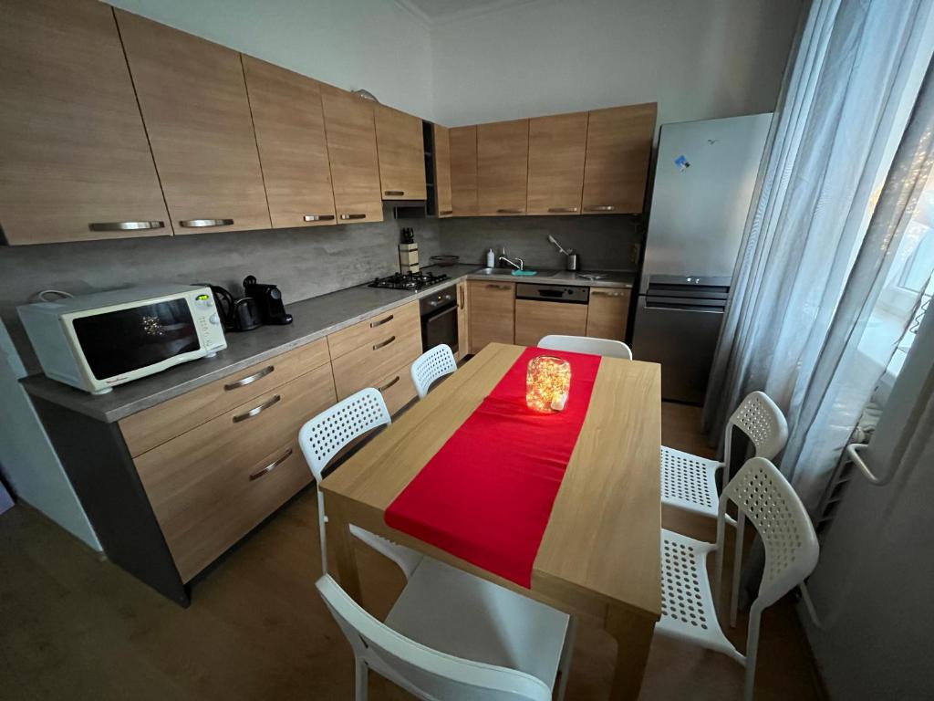 - une cuisine avec une table en bois, des chaises et un four micro-ondes dans l'établissement Apartmán Raisova 1180, à Karlovy Vary