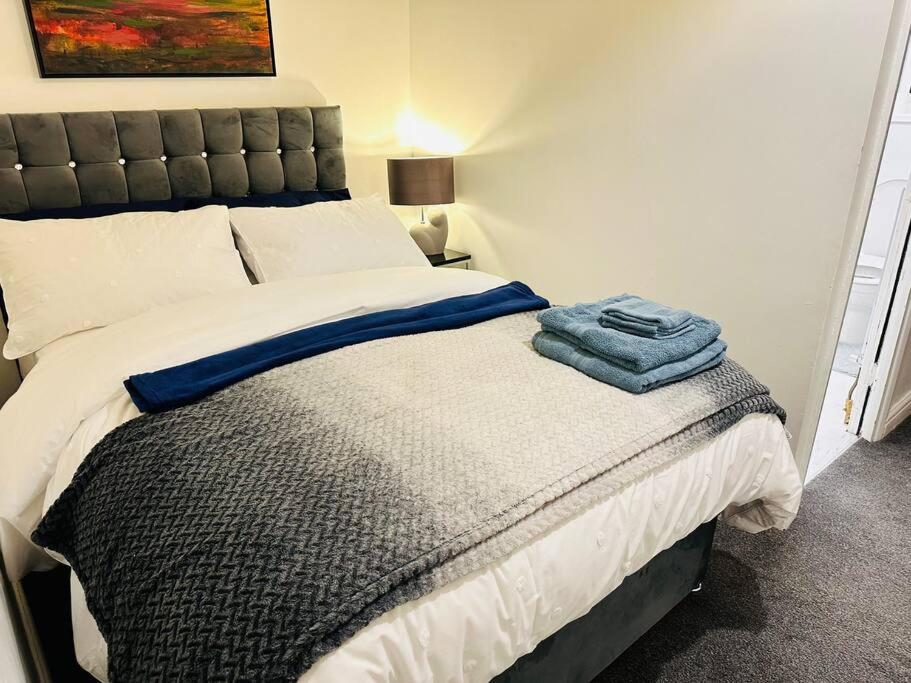 a bedroom with a bed with a blue towel on it at 1 Luxe Exec Bedroom Apt Derby in Derby