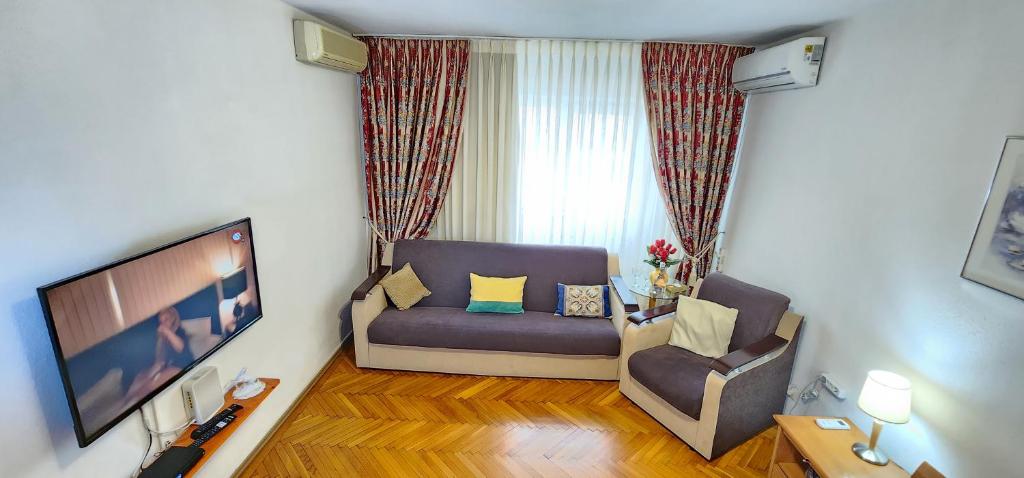 a living room with a couch and a tv at Atlas Accommodation Studio Romana de Lux in Bucharest