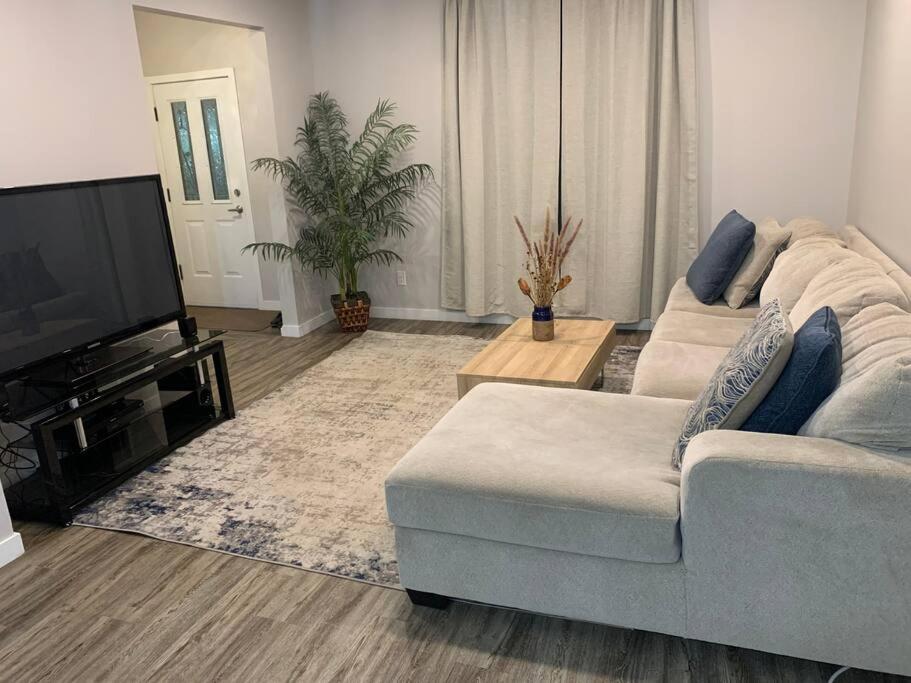 a living room with a couch and a flat screen tv at Sleek 3 bedroom home close to Exchange W parking in Winnipeg