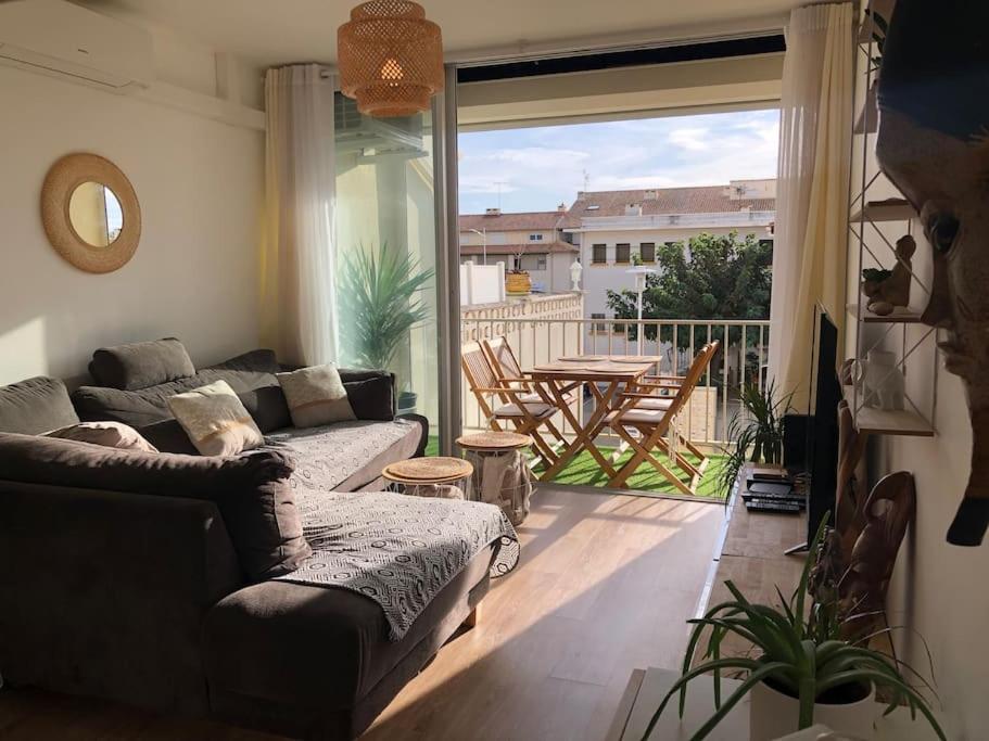 a living room with a couch and a table on a balcony at Le Corail - Superbe Duplex 3 chambres 6 personnes in Le Grau-du-Roi