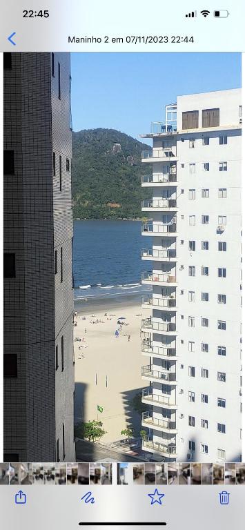- une vue sur la plage et deux bâtiments dans l'établissement AP em CONDOMINIO BEIRA MAR com GARAGEM, WIFI e TV A a CABO, à Balneário Camboriú