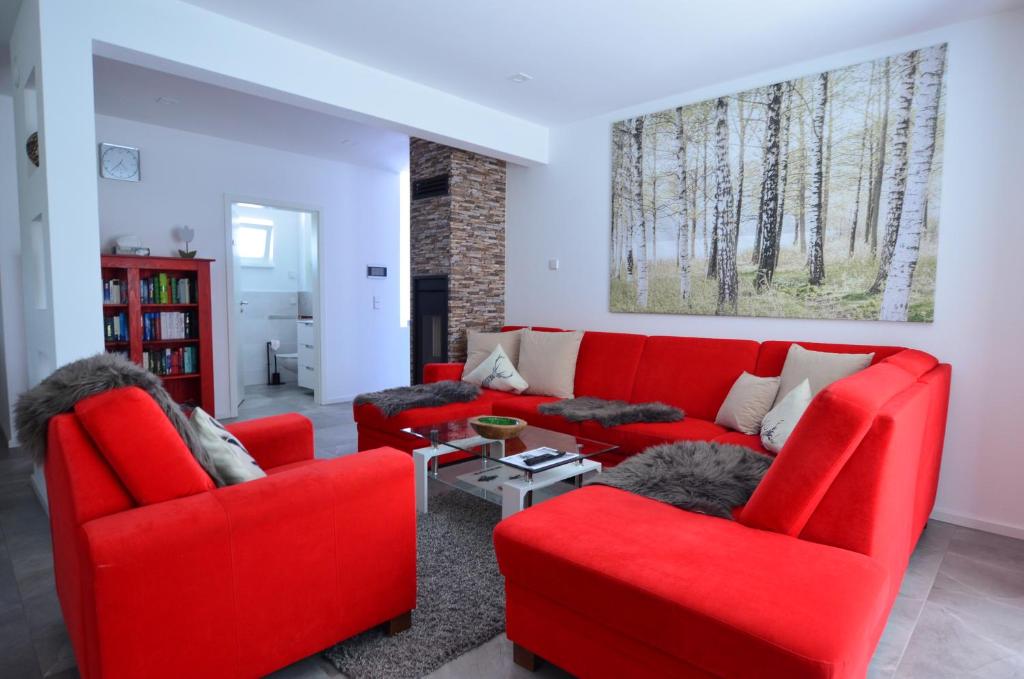 een woonkamer met rode stoelen en een rode bank bij Lechbruck am See - DAS STEINHÄUBL in Lechbruck