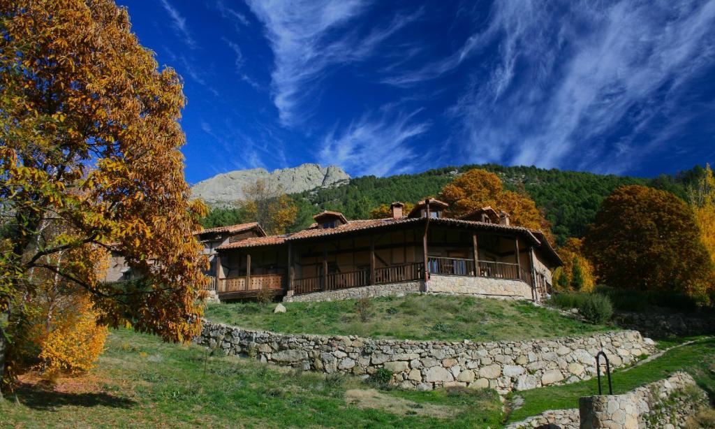 Hotel Rural Abejaruco في Cuevas del Valle: منزل على تلة بجدار حجري