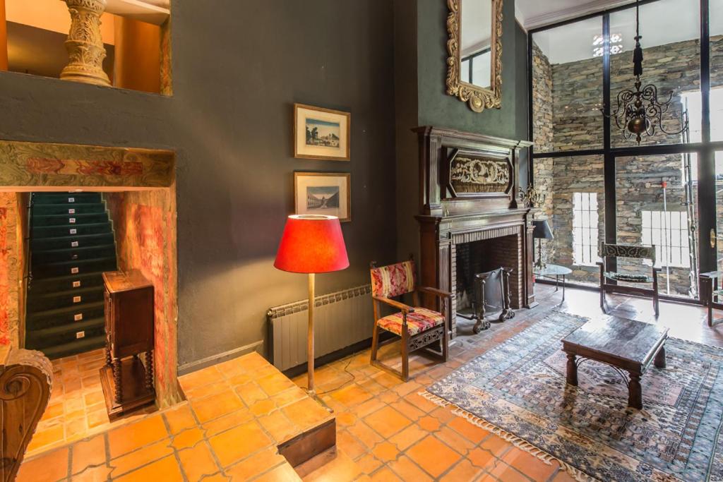 a living room with a fireplace and a lamp at El Mirador de Las Jaras in Patones