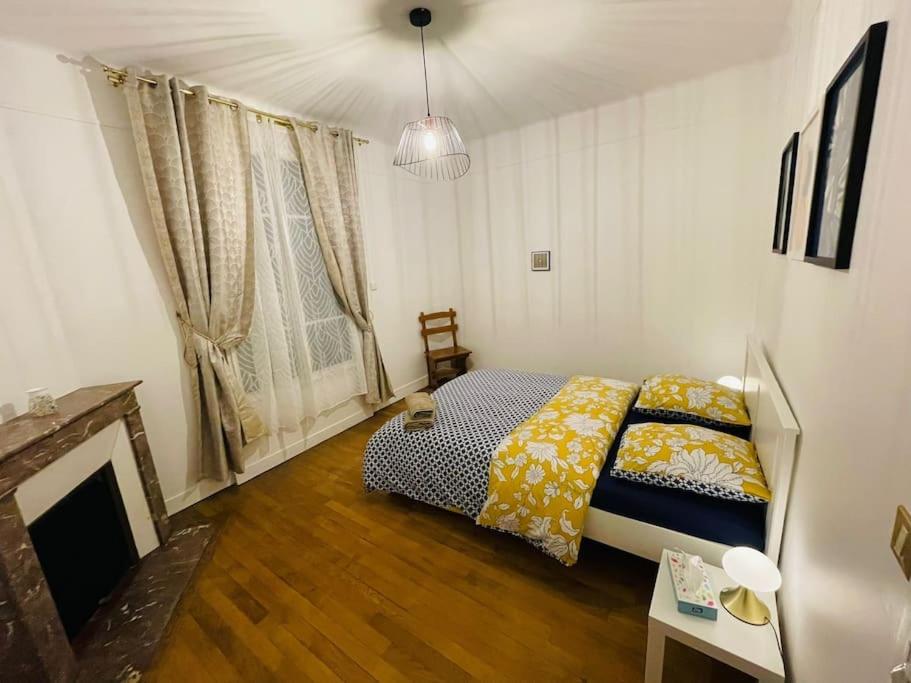 - une chambre avec un lit et une cheminée dans l'établissement Grande maison : Près de Paris/Orly, à Villeneuve-le-Roi