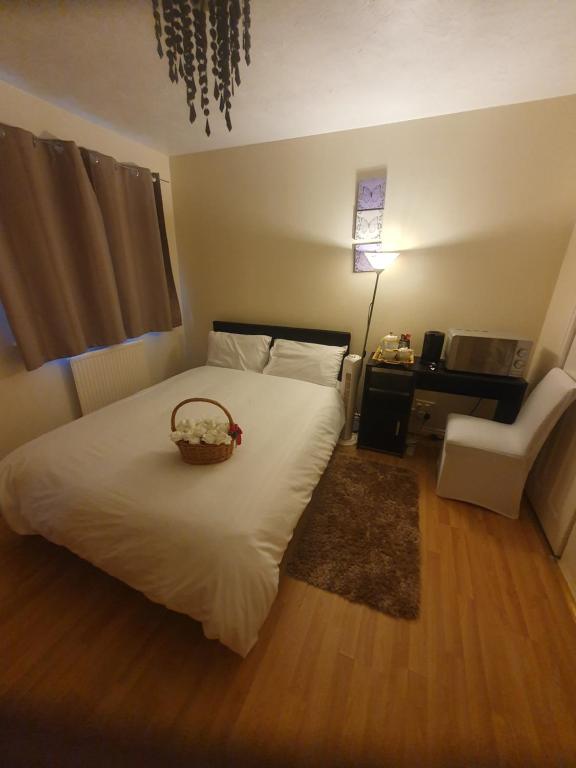 a bedroom with a bed with a basket on it at Double size and Single room in Barking in Barking