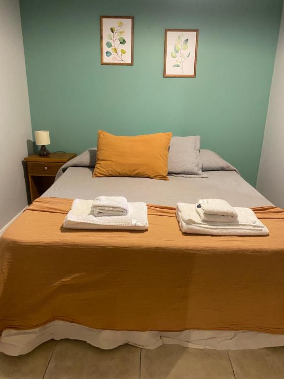 Una cama con dos toallas encima. en Departamento centro de san martin de los andes LA NONITA en San Martín de los Andes