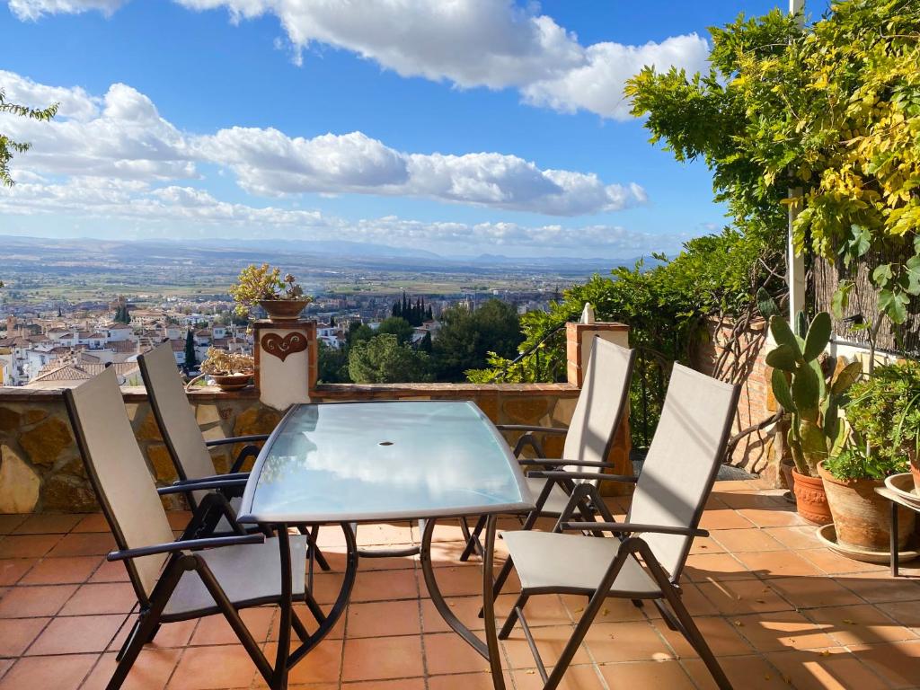 un tavolo e sedie su un balcone con vista di VillaSanMiguelAlto a Granada