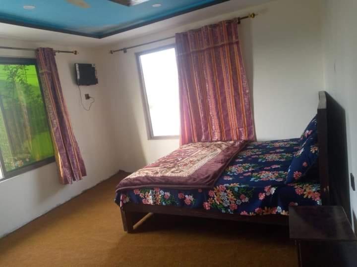 a bedroom with a bed and a window at Shama Resort Hotel in Skardu