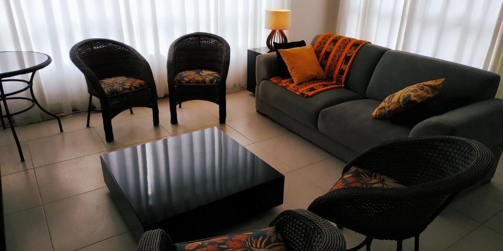 a living room with a couch and chairs and a table at Apartamento Confortável em Capão in Capão da Canoa
