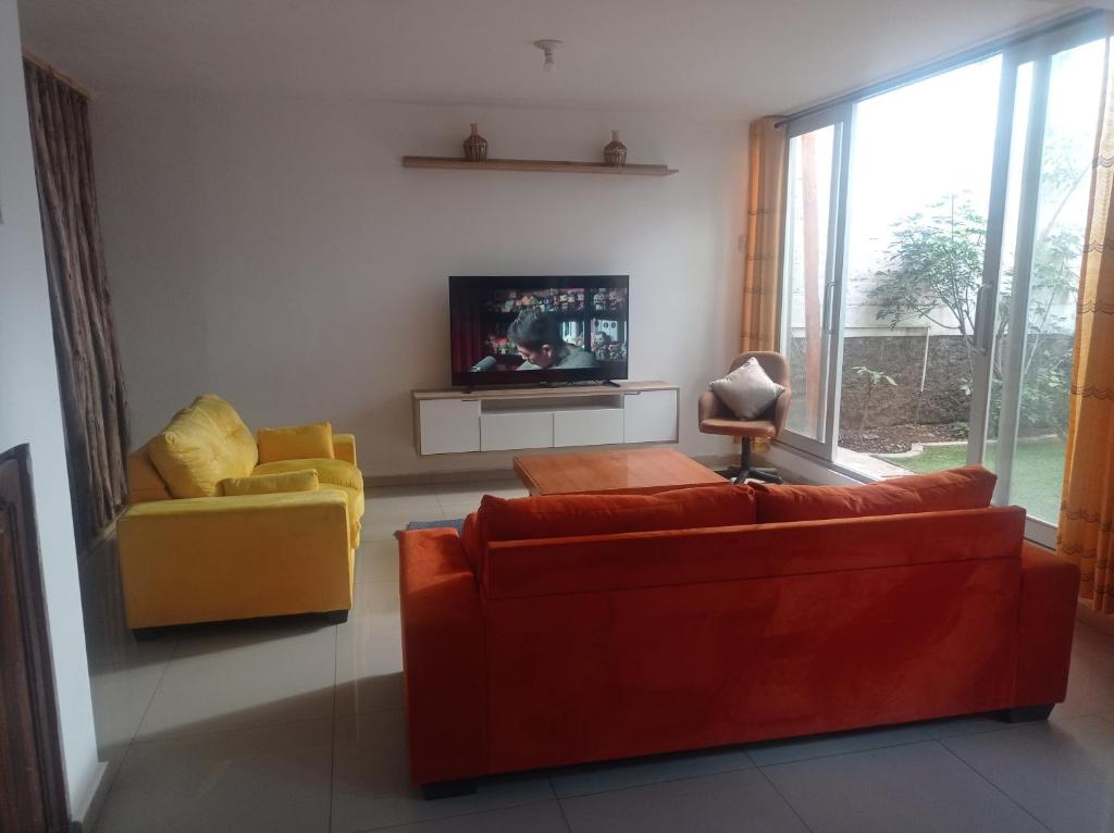sala de estar con 2 sofás y TV en TAWA 2, en Huancayo