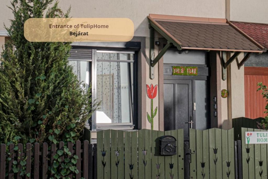 ein Haus mit einem Zaun davor in der Unterkunft Tulip Home Guest House in Vác