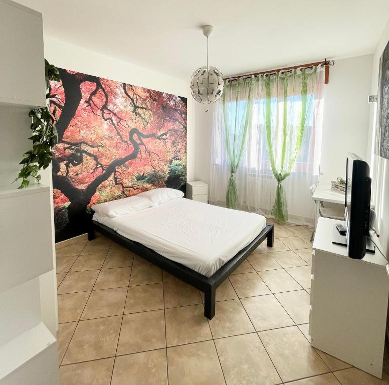 4th FLOOR ROOMS private rooms in apartment في تورينو: غرفة نوم بسرير وتلفزيون على جدار