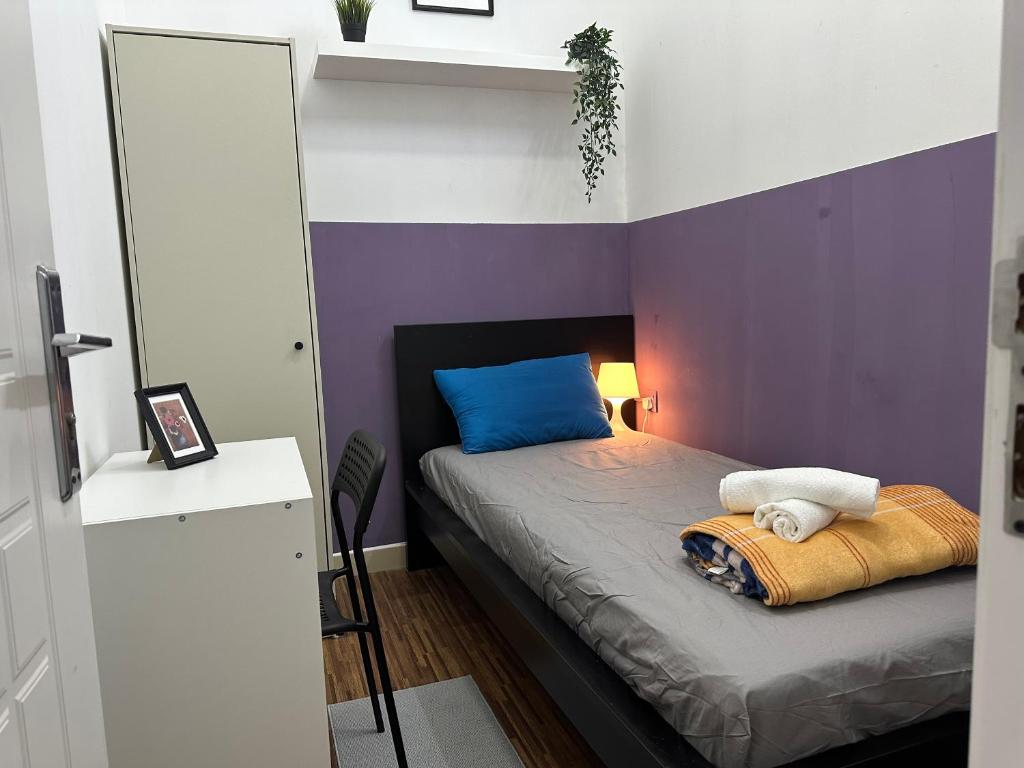 a bedroom with a bed with a purple wall at Prime Partition Room in Al Barsha 1 Near Metro in Dubai