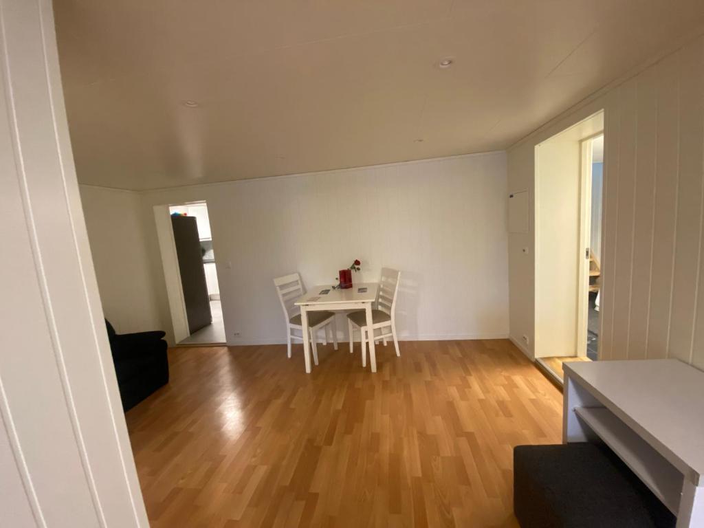 a white dining room with a table and chairs at Lovely one bedroom apartment in Tromsø