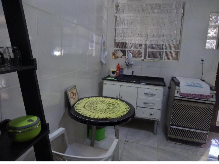a small kitchen with a table and a sink at Casa Inteira e Tranquila em Taboão da Serra in Taboão da Serra