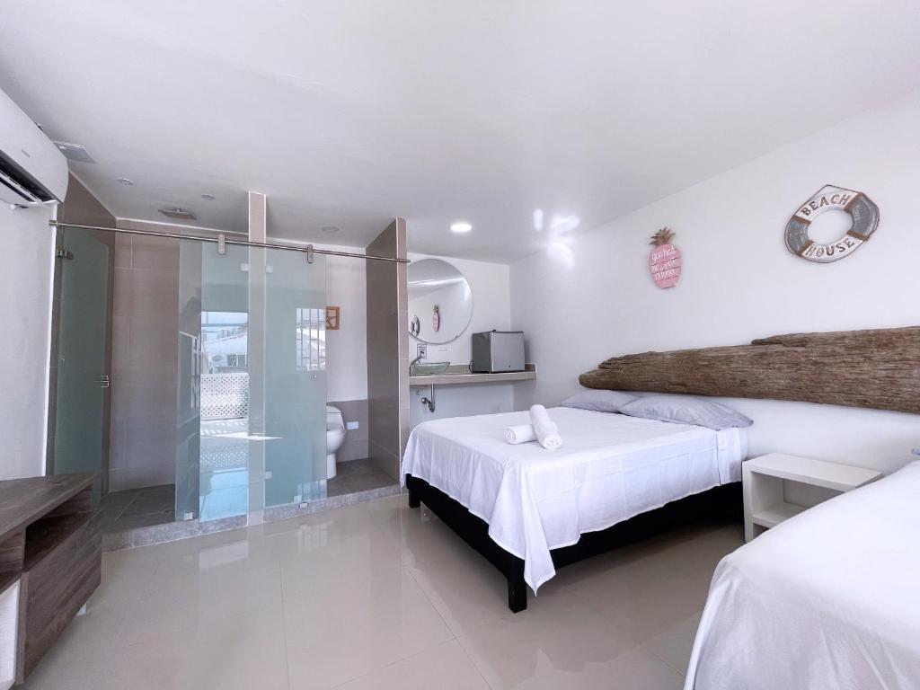 Habitación blanca con cama y ducha en Island Vibes, en San Andrés