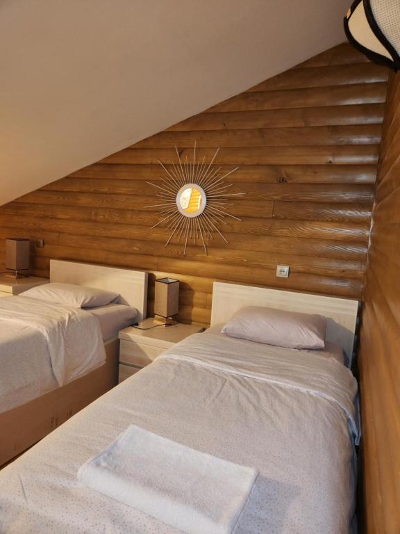 a bedroom with two beds and a mirror on the wall at Sanli in Mestia