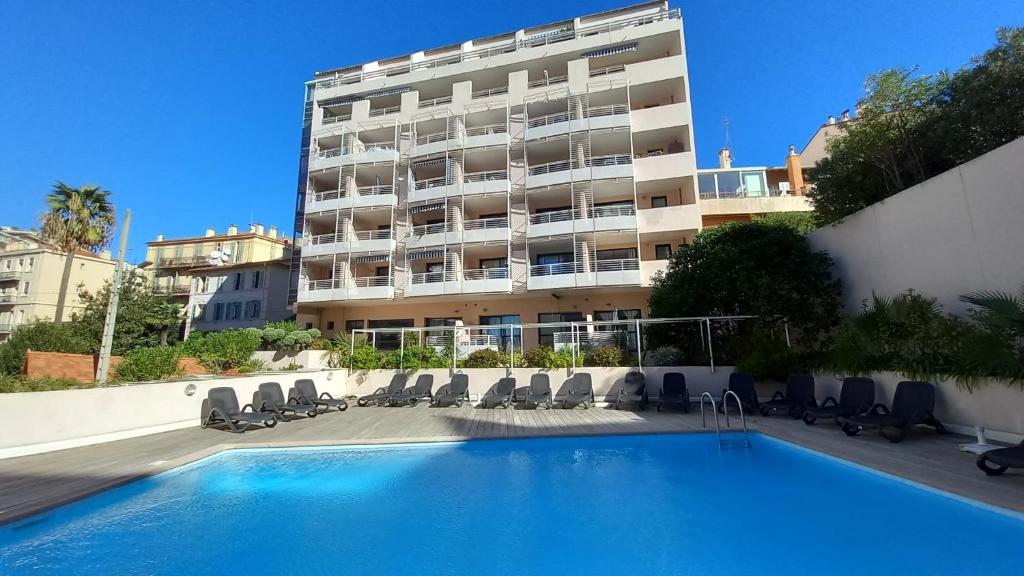 un hôtel avec une piscine devant un immeuble dans l'établissement Les Félibriges, à Cannes