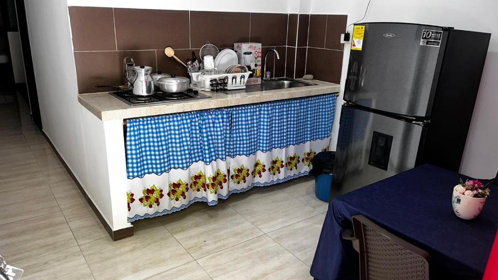 uma pequena cozinha com um lavatório e um frigorífico em EL EDÉN 102 em Puerto Triunfo