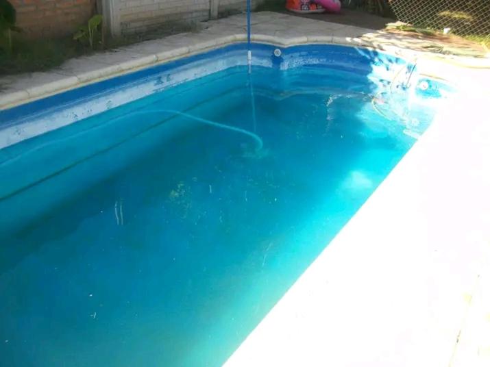 una piscina azul con una fuente de agua en Pileta quincho parque 8 personas grand bourg comfirmar reserva x telefono en Grand Bourg