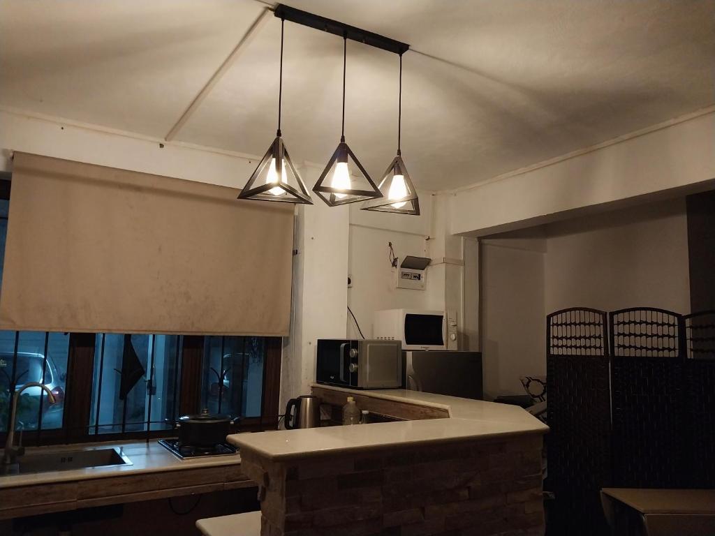 a kitchen with three lights hanging from the ceiling at Love cosy studios F2 in Flic-en-Flac