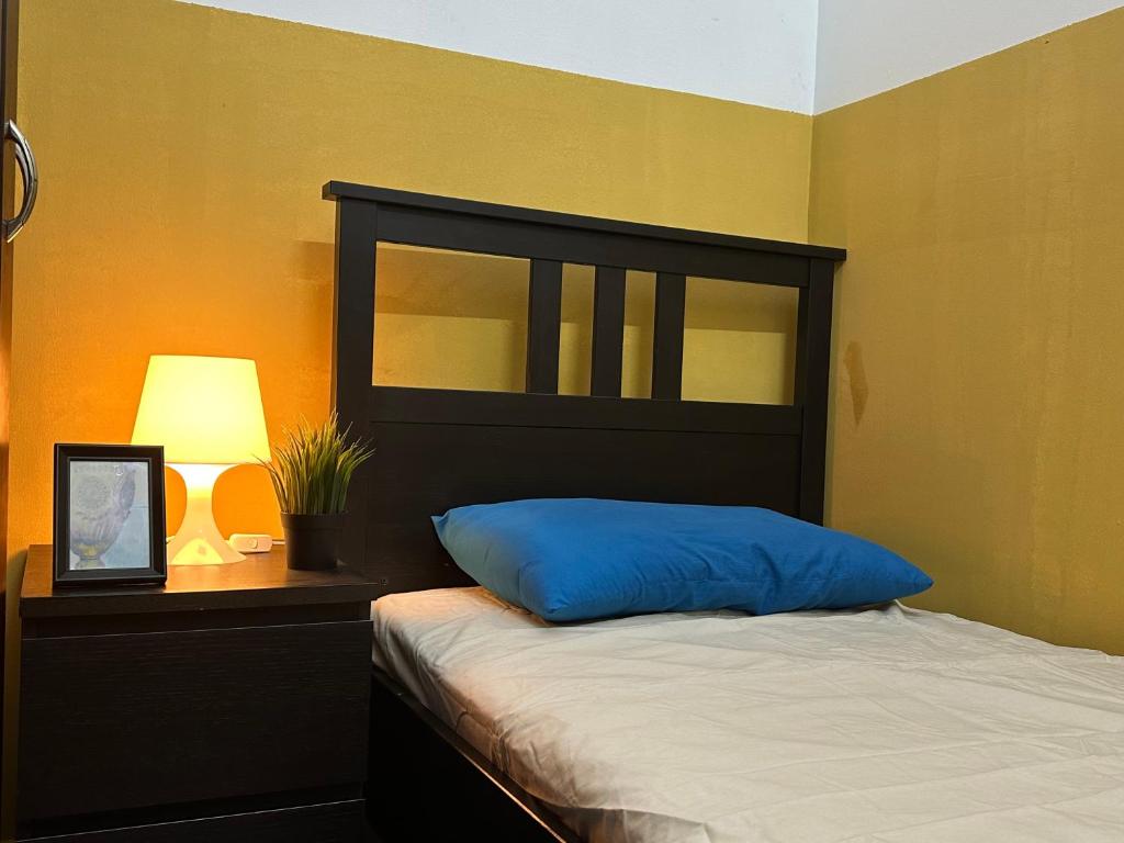 杜拜的住宿－Cozy Partition Room Near Mashreq & MOE Metro，一间卧室配有一张带蓝色枕头和灯的床
