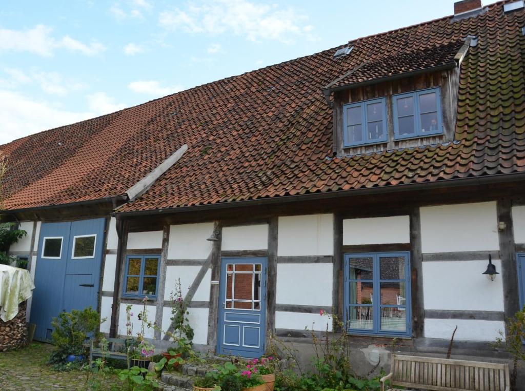 a house with blue doors and a brown roof at Ferienwohnung im Edelhof in Neustadt am Rübenberge