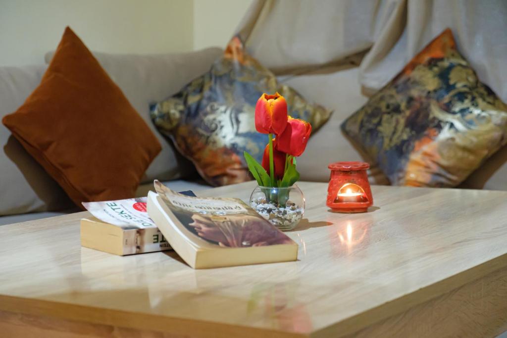 un tavolo con libri e un fiore e una candela di Simons house a Marrakech