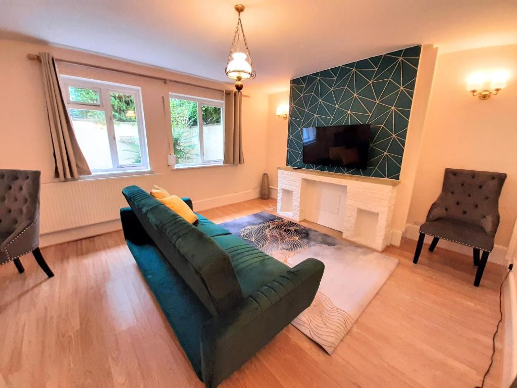 Wokingham - Central 2 beds home with parking في وكينغهام: غرفة معيشة مع أريكة ومدفأة