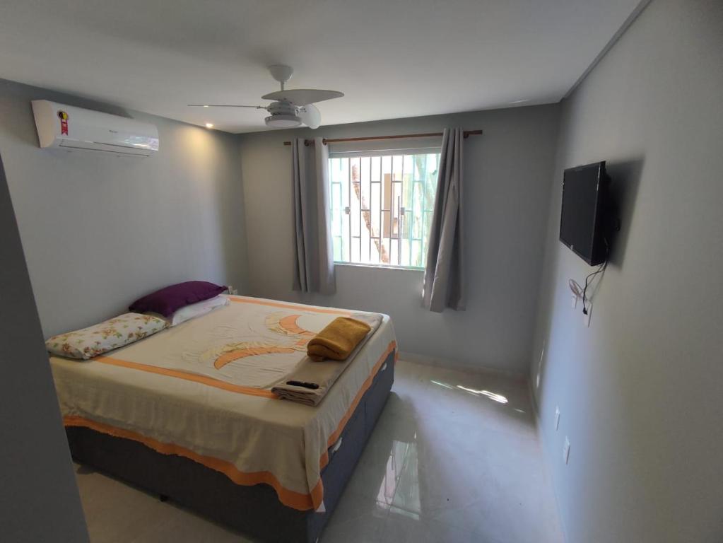 małą sypialnię z łóżkiem z oknem w obiekcie Casa de Praia - Guriri w mieście São Mateus