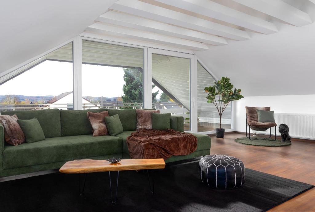 uma sala de estar com um sofá verde e uma mesa em Lichterfüllte Erholungsoase für Groß und Klein em Schwerte