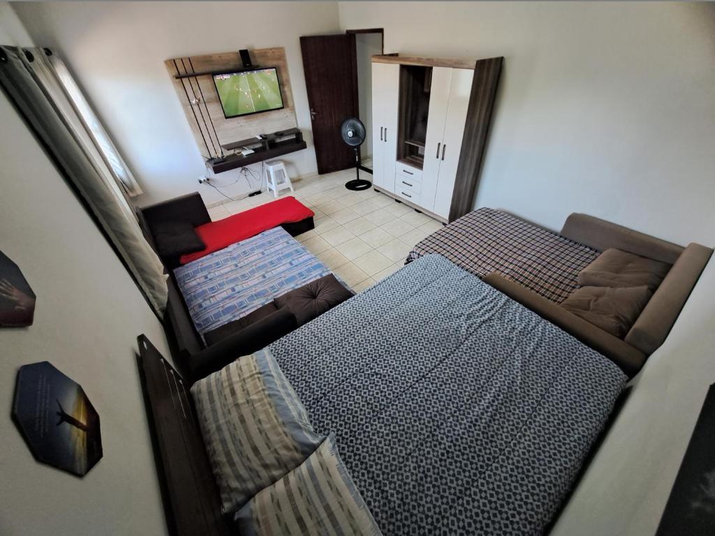 Vistas a una sala de estar con cama y sofá. en Condomínio Vitória, en Vila Velha