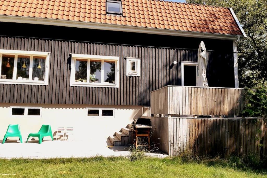 a house with two green chairs on the side of it at Nice two room flat 15 minutes from Stockholm C . in Huddinge