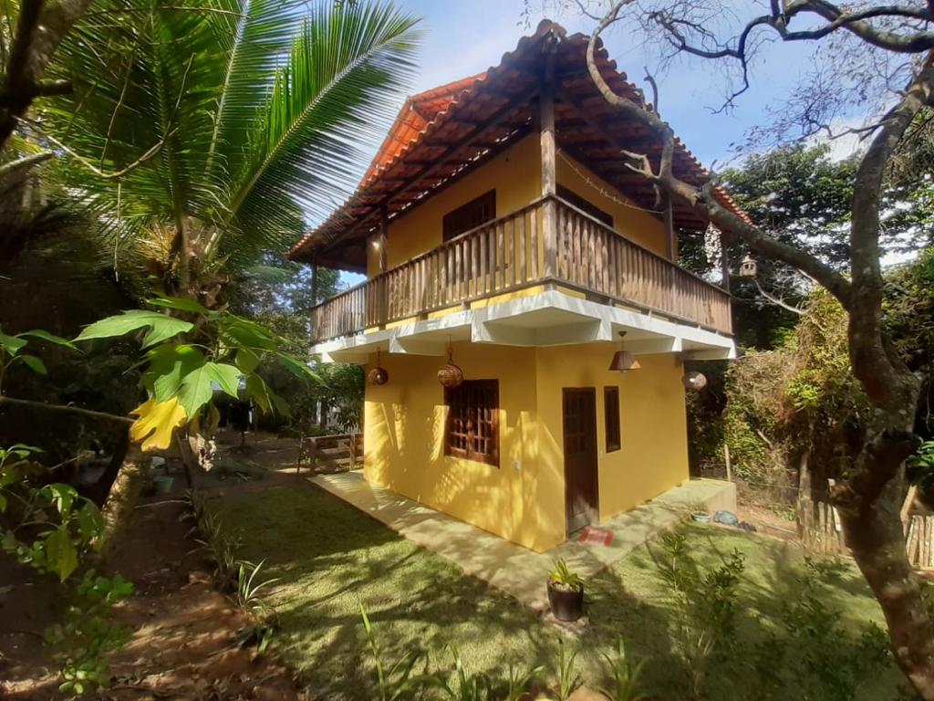 uma casa amarela com uma varanda em cima em Madeirascamping na Ilha de Boipeba