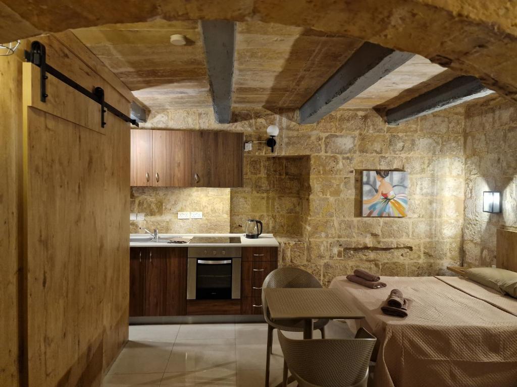 eine Küche mit einem Tisch mit Stühlen und einer Theke in der Unterkunft Renovated 16th Century House in Valletta in Valletta