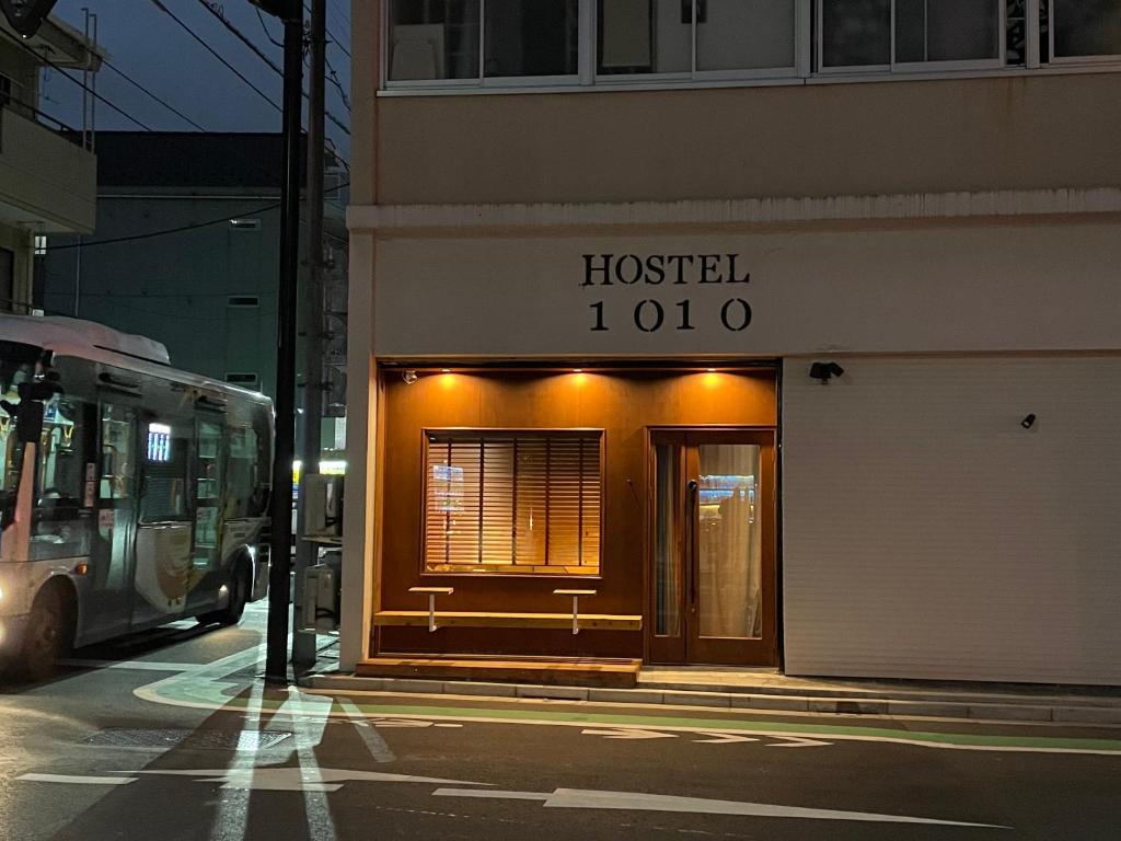 uma loja de hospital em uma rua da cidade à noite em Hostel 1010 SENJUOHASHI em Tóquio